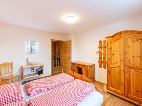 a bedroom with a bed and a wooden cabinet at Farmhouse in Bramberg with Natural Pond in Dorf