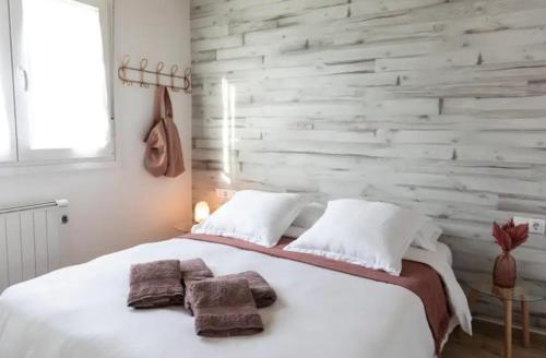 a bedroom with a large white bed with towels on it at Hogar con encanto y personalidad in L'Ametlla del Vallès