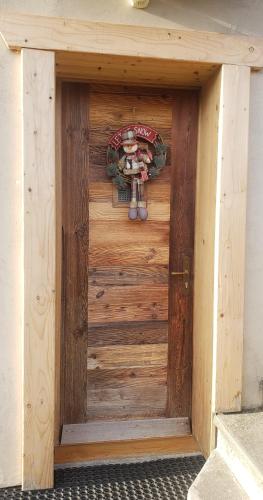 une porte en bois avec un panneau sur le côté du bâtiment dans l'établissement Appartement 2 pièces cuisine Les Hermines, à Saint-Nicolas-la-Chapelle