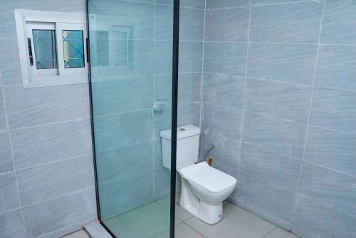 a bathroom with a toilet and a glass shower at Maison meublée avec parking et jardin in New Bell