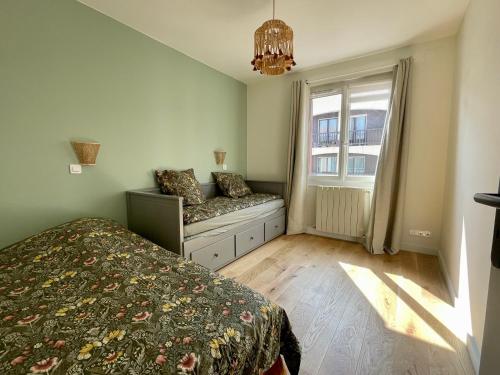 - une chambre avec un lit et une fenêtre avec un banc dans l'établissement Escapade Luzienne, à Saint-Jean-de-Luz