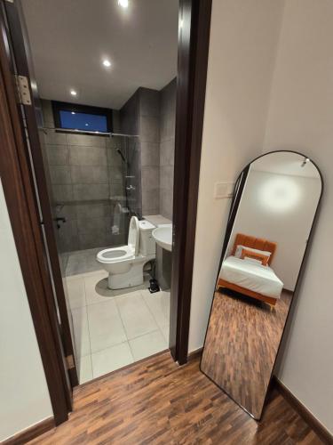 a bathroom with a mirror next to a toilet at K Avenue Kota Kinabalu by Merveille - Sabah in Donggongon
