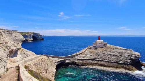 un phare au bord d'une falaise près de l'océan dans l'établissement Maison 3 chambres à Bonifacio, à Bonifacio