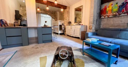 un salon avec un canapé bleu et une cuisine dans l'établissement Hypercenter - WiFi - Loft with character !, à Avignon