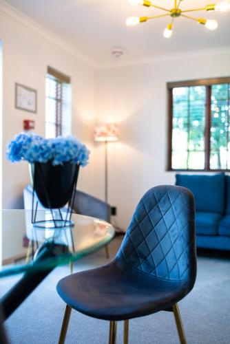 a living room with blue chairs and a glass table at Palm House Boutique Hotel and Spa in Cape Town