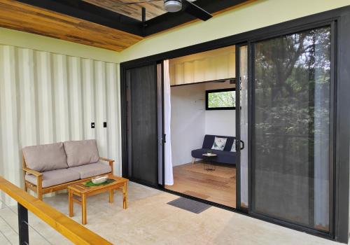 a living room with a couch and a sliding glass door at Casas del bosque Nosara in Nosara