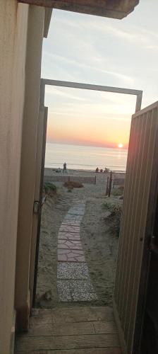an open door leading to the beach at sunset at Casa Roberto Beach in Torvaianica