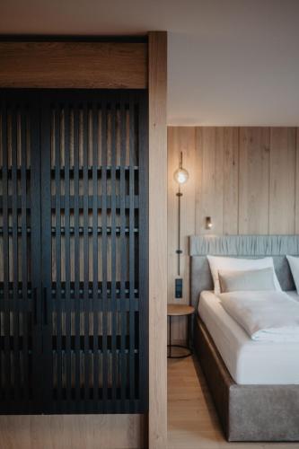 a bedroom with a bed and a wooden wall at Hotel Berghof - St Johann in Salzburg in Sankt Johann im Pongau