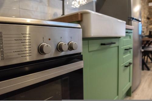 a kitchen with a stove and green cabinets at The Lake House Angeliki in Kanália