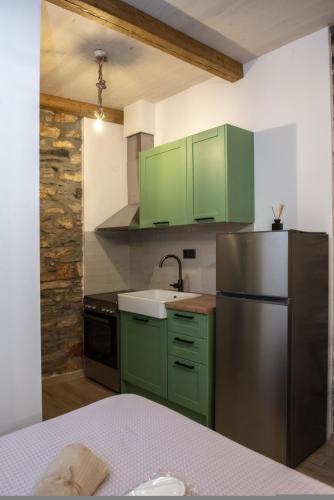 a kitchen with green cabinets and a stainless steel refrigerator at The Lake House Angeliki in Kanália