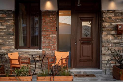 a house with chairs and a door with a lion head on it at The Lake House Angeliki in Kanália
