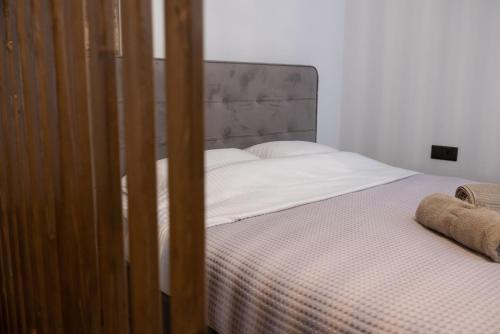 a bed with white sheets and a headboard in a room at The Lake House Angeliki in Kanália