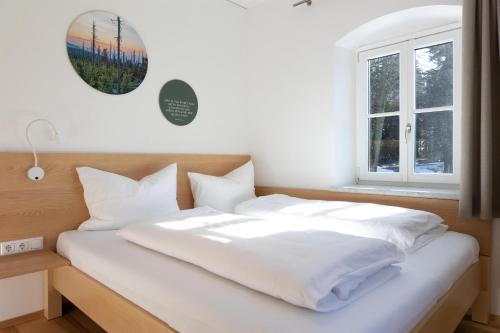 a white bed in a room with a window at Forsthaus Apartments - Die Ruheoase nahe Klaffer in Klaffer am Hochficht