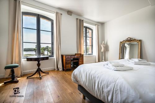 une chambre avec un lit, un miroir et un bureau dans l'établissement Manoir du Plessis Kaër, à Crach