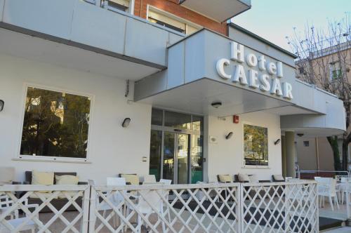 a restaurant with white tables and chairs in front of it at Hotel Caesar in Pesaro