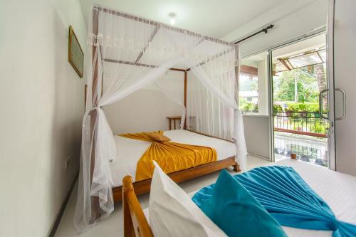 a bedroom with two beds and a window at ALP Tourist Guest House in Ella