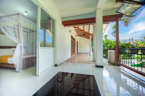 a bedroom with a bed and a balcony at ALP Tourist Guest House in Ella