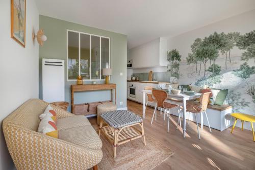 un salon avec un canapé et une table avec des chaises dans l'établissement À 220m de la plage, appart avec terrasse pour 3, à La Baule