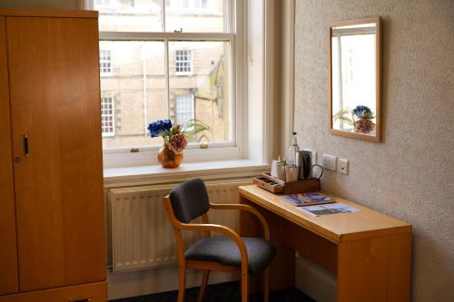 a desk with a chair in a room with a window at Ushaw Historic House, Chapels & Gardens in Durham