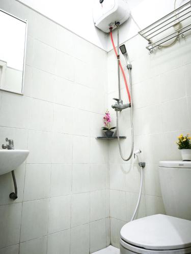 a bathroom with a shower and a toilet at Behomy Waru Sidoarjo in Djanti