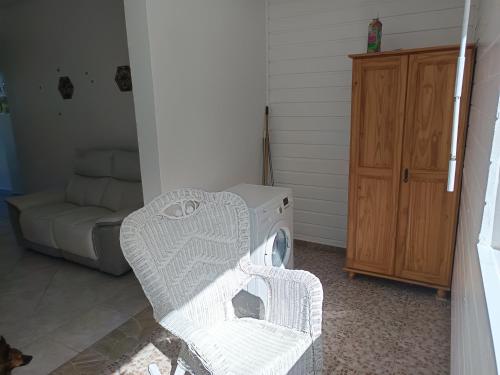 a laundry room with a washing machine and a couch at L'ASETA Paradise in Grand-Bourg