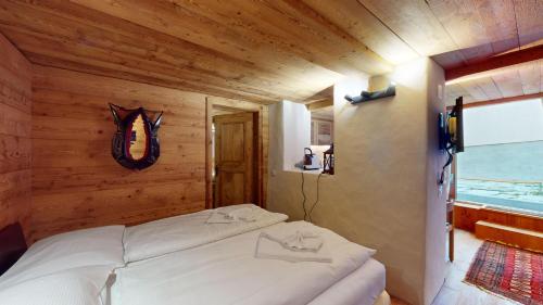 a bedroom with a white bed in a wooden room at Chesa Güglia Silvaplana in Silvaplana