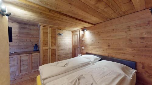 a bedroom with a bed in a wooden room at Chesa Güglia Silvaplana in Silvaplana