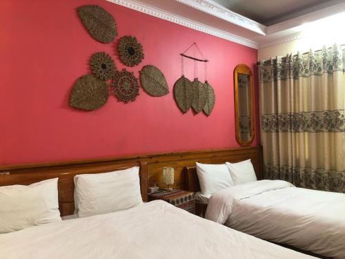 a bedroom with two beds and a pink wall at Sapa Family Homestay in Sa Pa