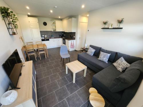 a living room with a couch and a kitchen at Haarle's kleine landhuis NR 3 in Haarle