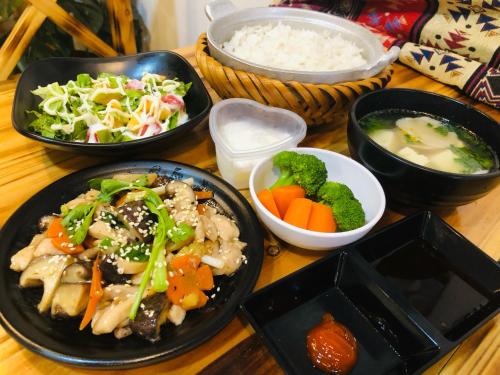 a table with plates of food and bowls of rice and vegetables at Sapa Family Homestay in Sa Pa