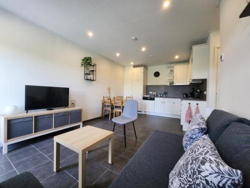 a living room with a couch and a table and a kitchen at Haarle's kleine landhuis NR 3 in Haarle