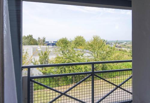 an open window of a balcony with a view of a field at B&B HOTEL Amiens in Longueau