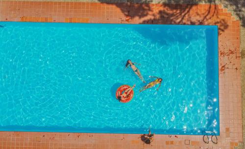 two people in a swimming pool with a ball in the water at Montebelli Agriturismo & Country Hotel in Caldana