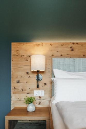 a bedroom with a bed and a lamp on a table at Biohotel Rupertus in Leogang