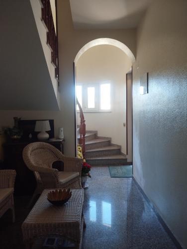 a hallway with an archway and a chair and stairs at B&B Villa Marinetti in Gela