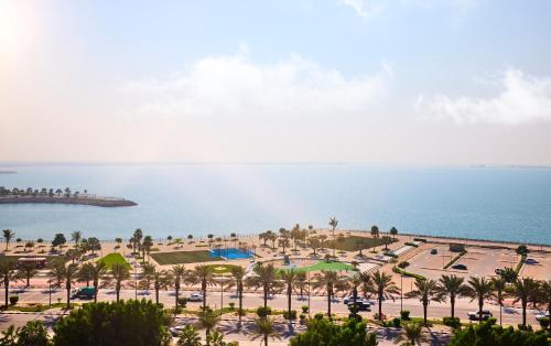 an aerial view of a beach with palm trees and the ocean at Rove Al Marjan Island in Ras al Khaimah