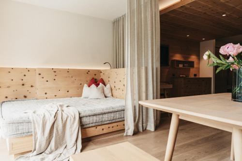 a bedroom with a bed and a table at Biohotel Rupertus in Leogang