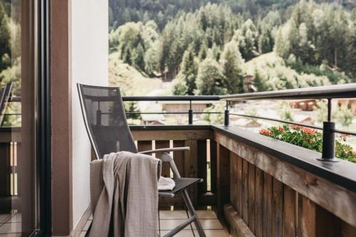 a chair sitting on a balcony with a view at Biohotel Rupertus in Leogang