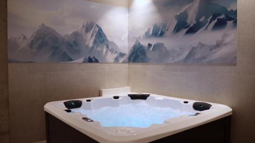 a bath tub in a bathroom with a mountain mural at Apartamentos 2H LIVING in León
