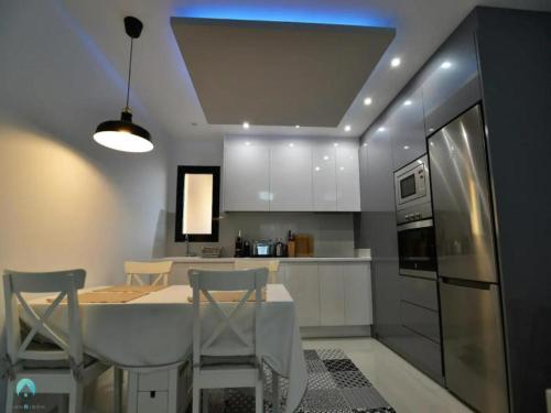 a kitchen with a table and chairs and a refrigerator at Ground floor apartment in Pilar de la Horadada - Mil Palmeras Beach in Pilar de la Horadada