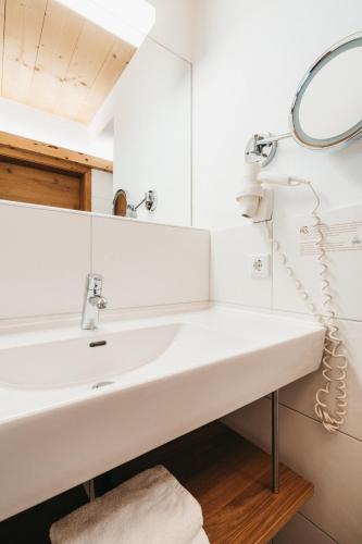 a bathroom with a white sink and a mirror at Biohotel Rupertus in Leogang