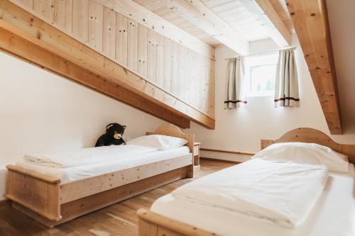 two beds in a room with a dog sitting on top at Biohotel Rupertus in Leogang