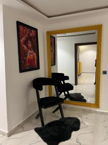 a mirror in a room with two chairs in front of it at OD Cribs Luxury Apartment and On demand Car Service in Aso