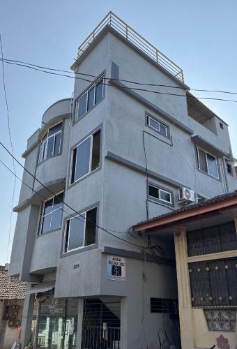 a tall grey building with windows on top of it at soge holiday lodging in Srīvardhan