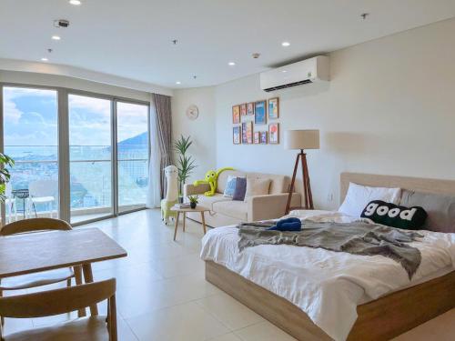 a bedroom with a bed and a table and chairs at The Song Apartment 5 Stars Vung Tau - Căn Hộ Du Lịch 5 Sao Cạnh Biển - Dumin's Homestay in Vung Tau