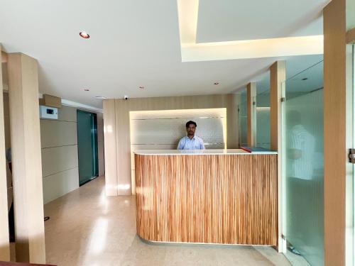 a man standing behind a counter in a kitchen at Bandra Stays in Mumbai