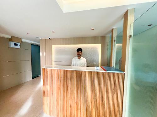a man standing behind a counter in a room at Bandra Stays in Mumbai