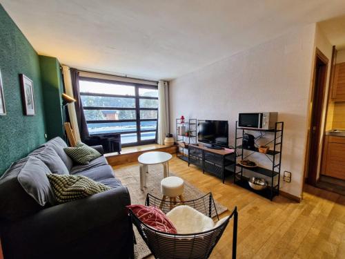 a living room with a couch and a tv at Hauzify I Domus Molina in La Molina