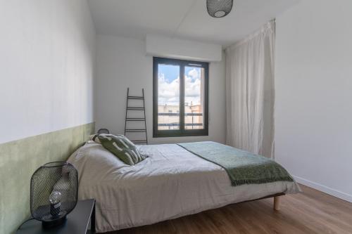 een slaapkamer met een bed en een raam bij Abondance 16 in Cergy