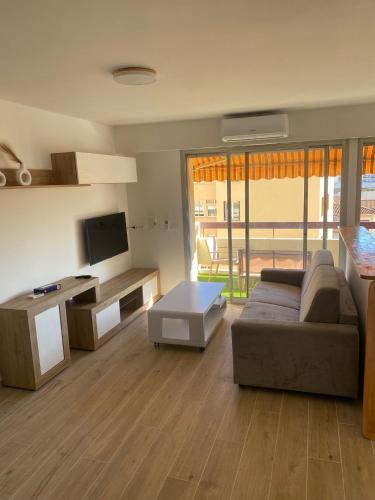 a living room with a couch and a tv at Studio Kialeo près de la plage avec parking voiture in Roquebrune-Cap-Martin